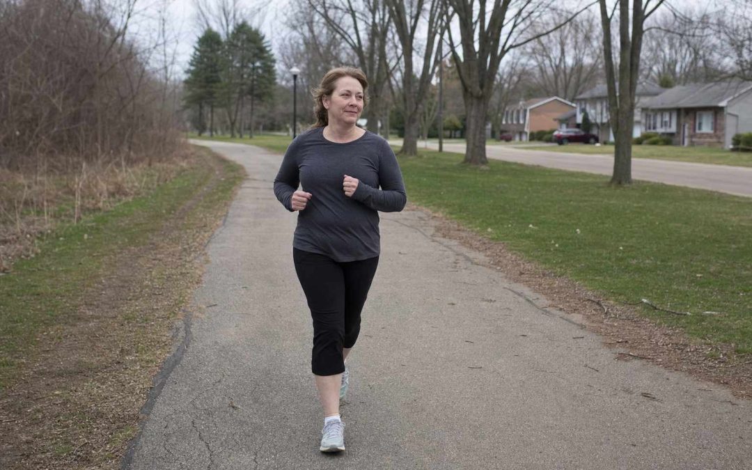 An ordinary person starting a gentle jog-walk on a neighborhood path